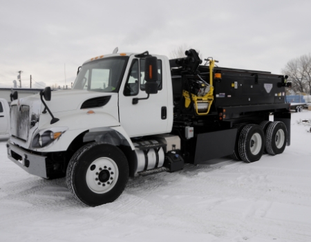 large asphalt patching truck in the snow